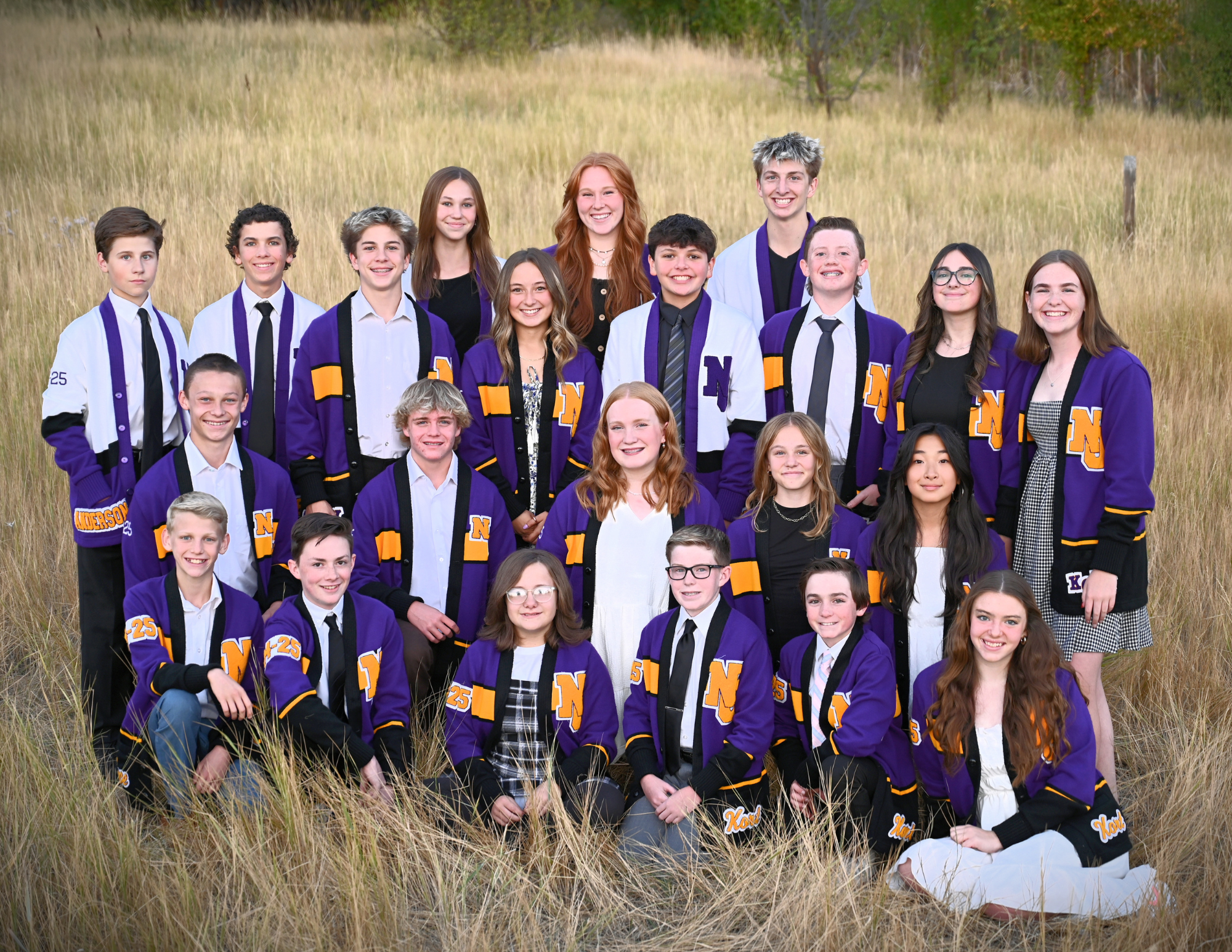 All officers standing in a field wiith white purple and gold jackets