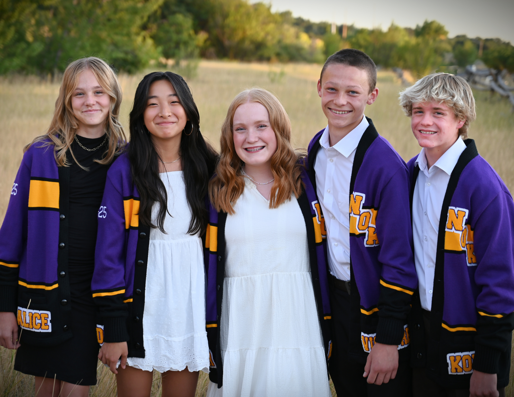 5 8th grade officers in a field with purple jackets