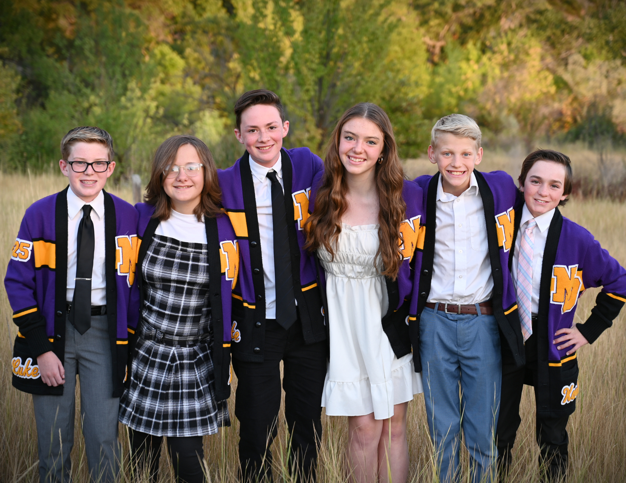  6 7th grade officers in a field with purple jackets